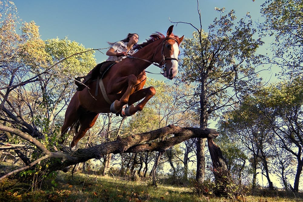 Woman horseback riding without helmet